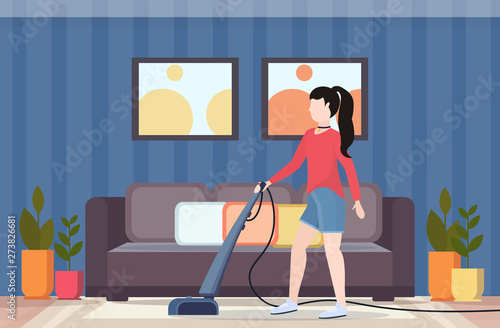 woman using vacuum cleaner housewife doing housework floor care concept modern living room interior flat full length horizontal