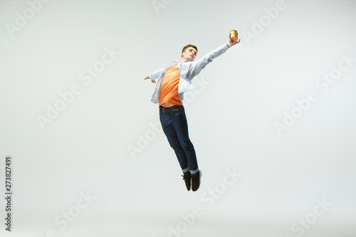Happy young man working at office, jumping and dancing in casual clothes or suit isolated on white studio background. Business, start-up, working open-space, ballet or professional occupation concept.