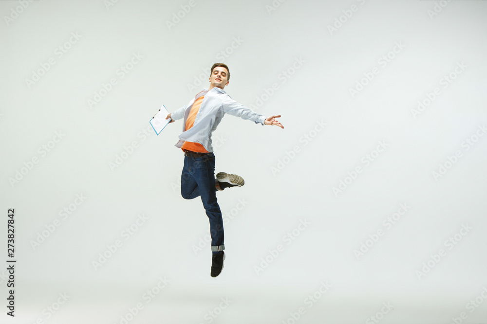 Happy young man working at office, jumping and dancing in casual clothes or suit isolated on white studio background. Business, start-up, working open-space, ballet or professional occupation concept. Happy young man working at office, jumping and dancing in casual clothes or suit isolated on white studio background. Business, start-up, working open-space, ballet or professional occupation concept.