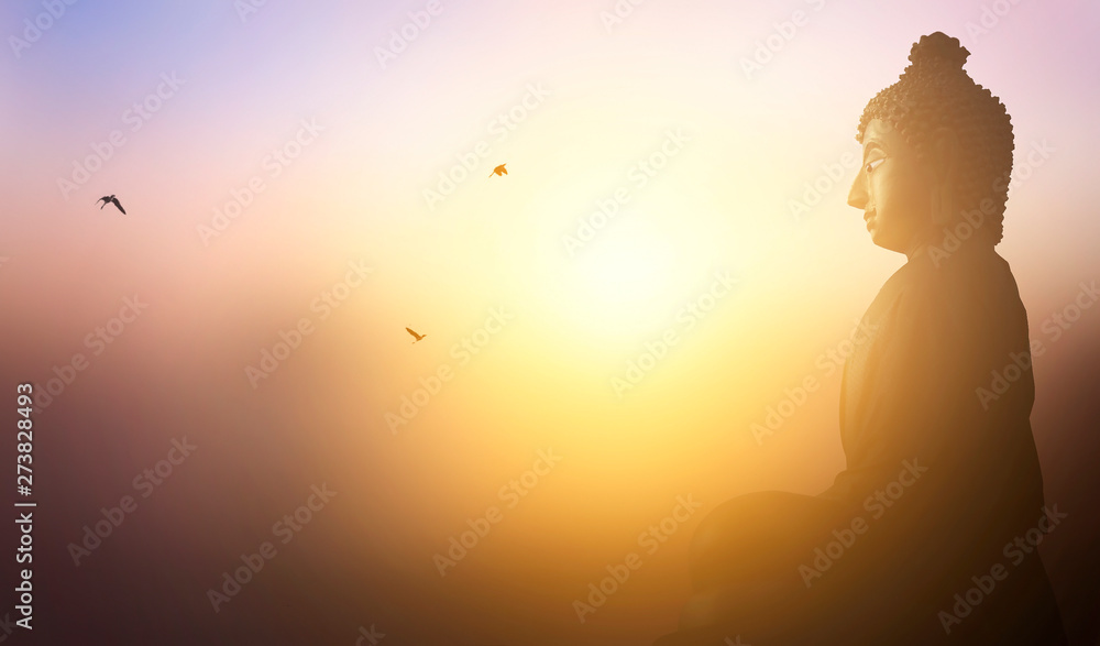 Buddhist concept: Buddha statue on the background of the sunset Buddhist concept: Buddha statue on the background of the sunset
