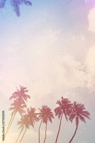 Coconut palm trees on ocean beach. Tropical coast palms vintage stylized with film light flare leaks.