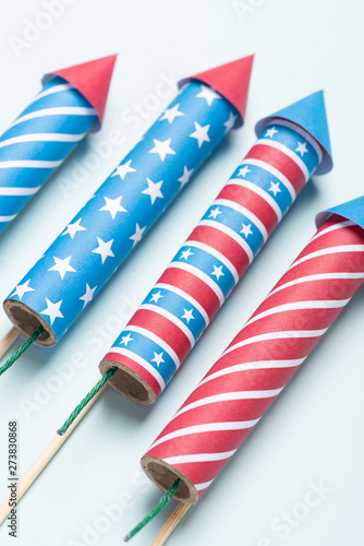 Fototapeta Naklejka Na Ścianę i Meble -  4th of july USA flag colors style rockets fireworks on blue background. Independence day firecrackers.