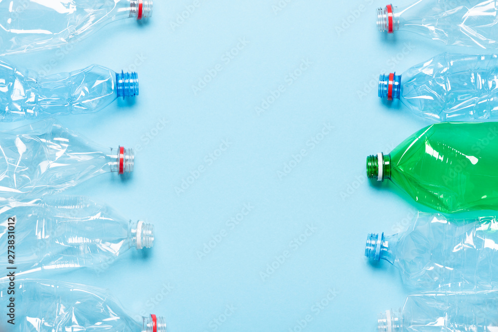 Single use plastic bottles on blue background with copy space top view