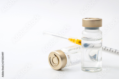 Vaccines, botulinum toxin and insulin ampules concept theme with glass vials with clear liquid next to a syringe and a hypodermic needle isolated on white background with copy space