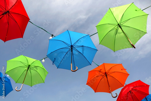 Colorful umbrellas and lightbulbs  sky in the background. Selective focus.