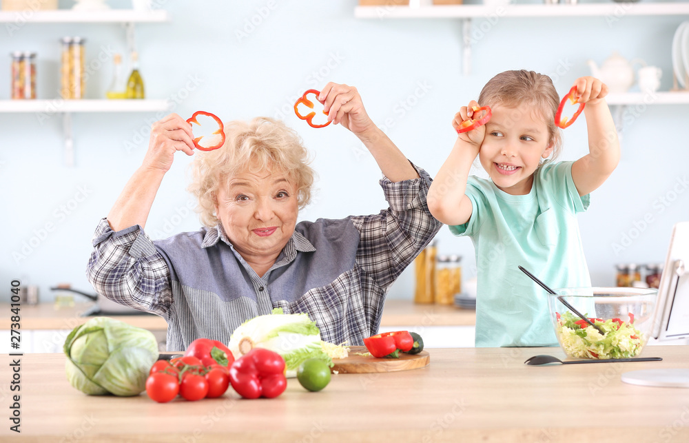 Cute little girl with grandmother having fun in kitchen Cute little girl with grandmother having fun in kitchen