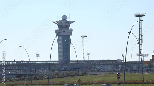Air control tower at Orly Sud Airport in Paris during sunny summer with beautiful blue sky and car traffic foreground. Pan to right then left. photo