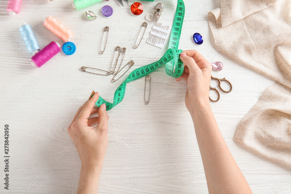 Female hands with measuring tape and accessories on white background Female hands with measuring tape and accessories on white background