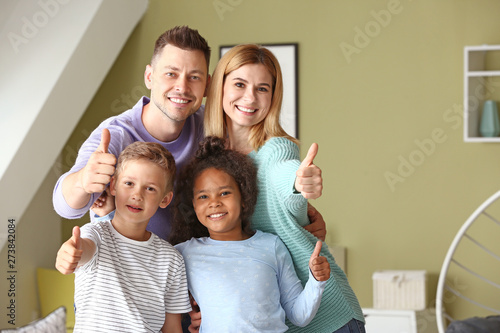 Happy couple with little adopted children at home
