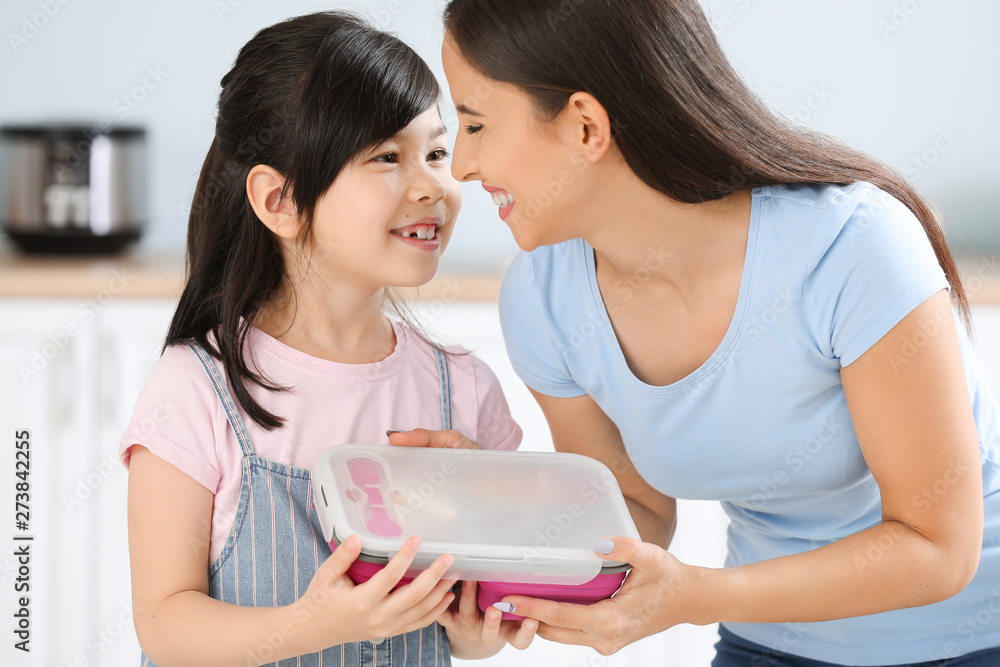 Mother and her little daughter with lunch box before school Mother and her little daughter with lunch box before school