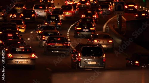 Paris, France - April 6, 2019: Car Traffic by night at Paris Parc Des Princes soccer stadium taken from bridge view. Lights, cars, fires, trees, bus, blur effect. Lot of vehicles. Blurred Tight Shot. photo