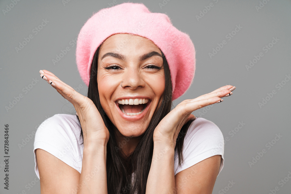 Photo closeup of surprised pretty woman in basic t-shirt and beret rejoicing and throwing up hands Photo closeup of surprised pretty woman in basic t-shirt and beret rejoicing and throwing up hands