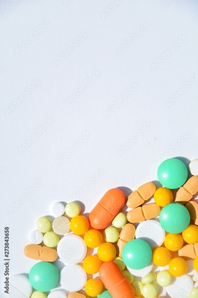 background with white, yellow, orange and green pills on a white background with space for text