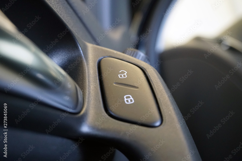 Close Up shot of button locking doors in car. Interior of a modern car. The door trim of a modern car. Close Up shot of button locking doors in car. Interior of a modern car. The door trim of a modern car.