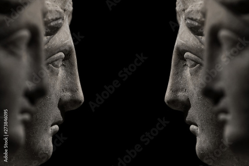 Obraz na plátně Symmetrical banner of marble ancient woman heads watching each other and arguing