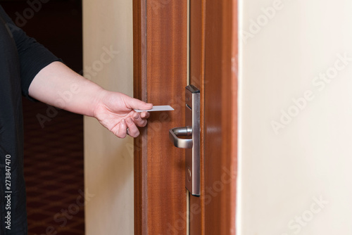 Female hand putting key card switch in to open hotel room door.