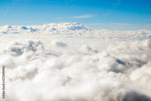 Flying above the clouds. Sunny view from the airplane, soft focus