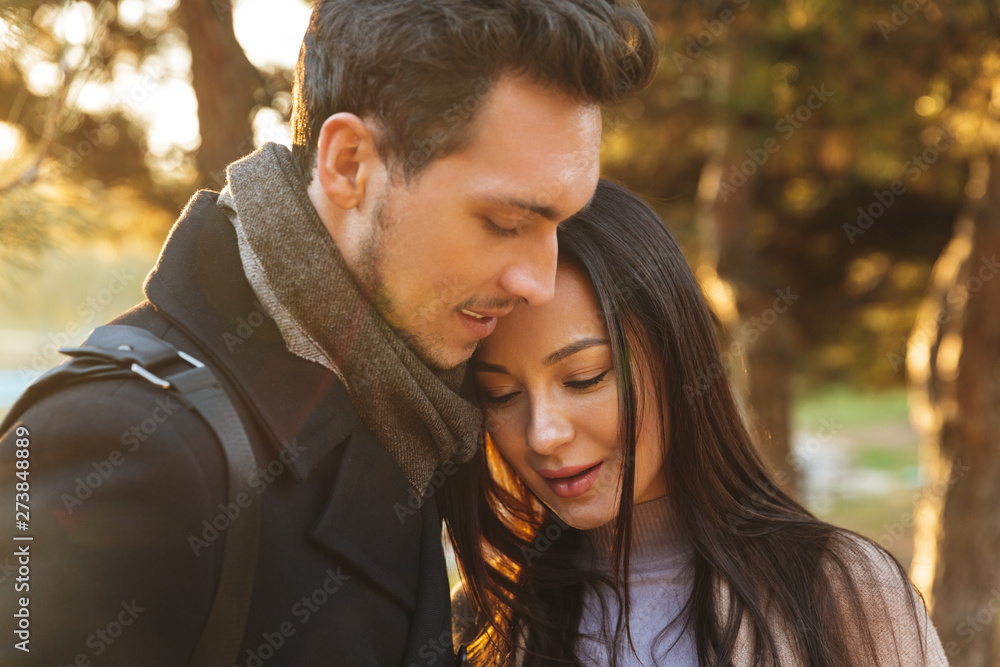 Beautiful loving couple posing walking hugging outdoors in park nature. Beautiful loving couple posing walking hugging outdoors in park nature.