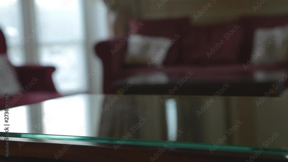 Car key resting on the glass table of a room of famous vintage luxury hotel, with red sofa in the blurred background, in the morning. Hand of a Caucasian businessman taking them fast and leaving. Car key resting on the glass table of a room of famous vintage luxury hotel, with red sofa in the blurred background, in the morning. Hand of a Caucasian businessman taking them fast and leaving.
