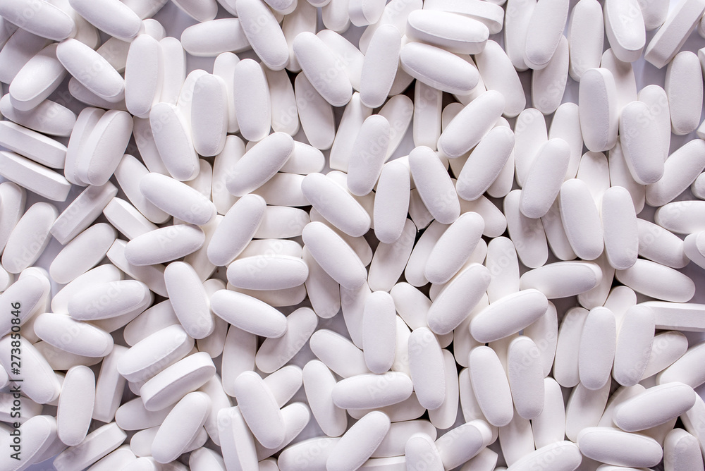 white pills on black background white pills on black background