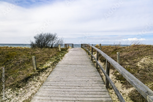 Wooden path at Baltic sea over sand dunes with ocean view