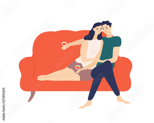 Cute couple sitting on sofa and drinking wine during romantic date