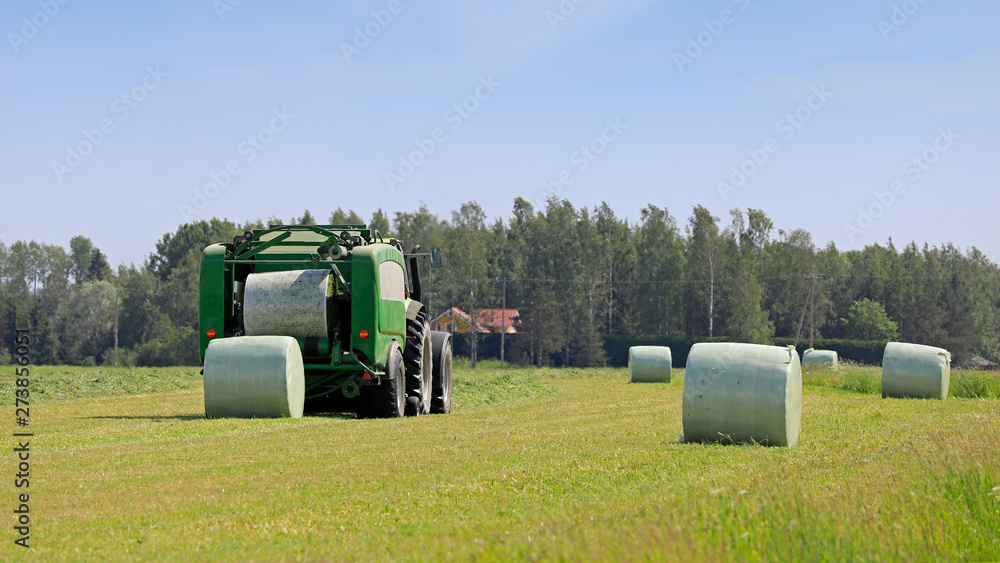Obraz premium Baler Wrapper Baling Silage in Field