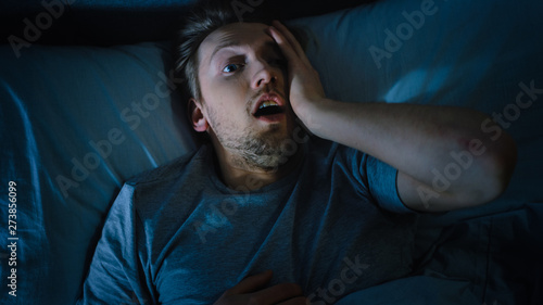 Top View of a Young Man in Bed at Night Having Terrible Nightmare, He Wakes Up Scared and Covered in Sweat.