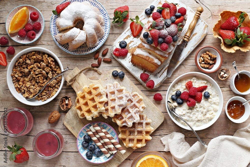 Happy breakfast with granola, oatmeal porridge, smoothies, fresh waffles, sweets, fruits and berries. Happy breakfast with granola, oatmeal porridge, smoothies, fresh waffles, sweets, fruits and berries.