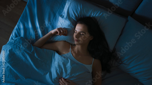 Cuadro en lienzo Top View of Beautiful Young Woman Sleeping Cozily on a Bed in His Bedroom at Night