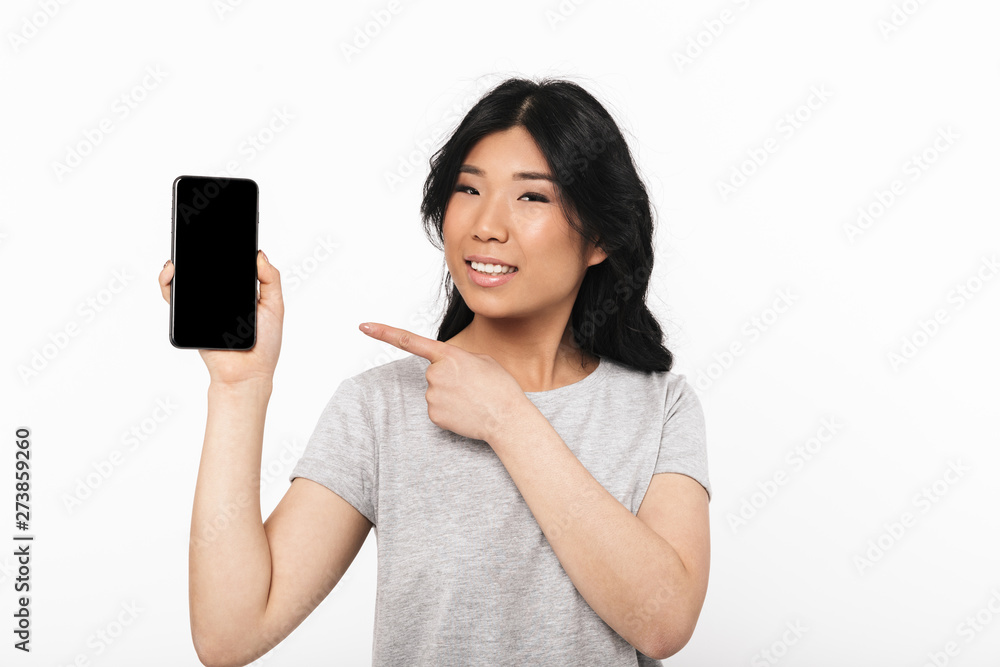 Beautiful young woman posing isolated over white wall background showing display of mobile phone. Beautiful young woman posing isolated over white wall background showing display of mobile phone.