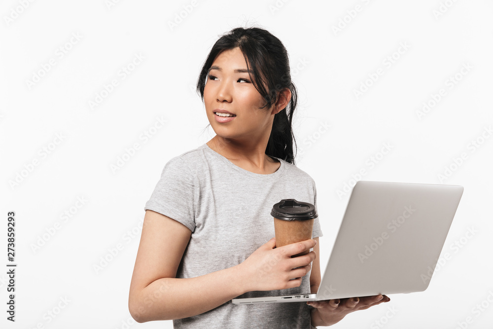 Asian beautiful young woman posing isolated over white wall background using laptop computer. Asian beautiful young woman posing isolated over white wall background using laptop computer.