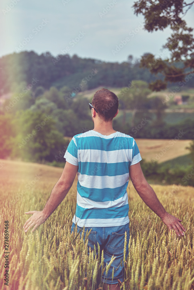 Man enjoying and relaxing in wheat field. Nature concept.