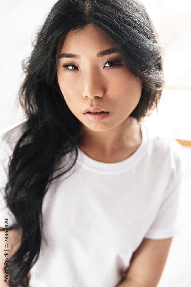 Asian beautiful young woman posing isolated over white wall background. Asian beautiful young woman posing isolated over white wall background.
