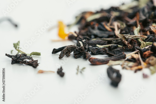 Dried tea leaves close up on white background