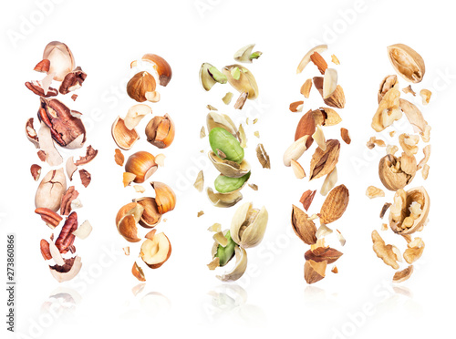 Set of various crushed nuts in the air on a white background