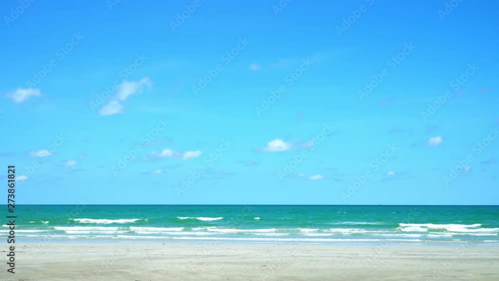 4K Landscape wide shot of empty azur sea and sand beach at tropical island with blue sky and white clouds backgrounds. Sea water waves rolling and splashing against the beach in hot summer day. 4K Landscape wide shot of empty azur sea and sand beach at tropical island with blue sky and white clouds backgrounds. Sea water waves rolling and splashing against the beach in hot summer day.