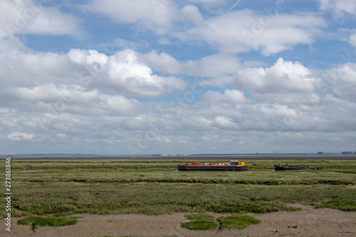 Barge and boats at Old Leigh, Essex, England, against a blue sky