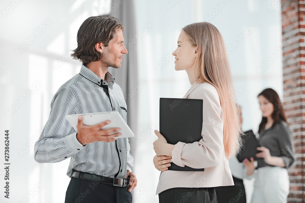 closeup.business colleagues standing on background modern office