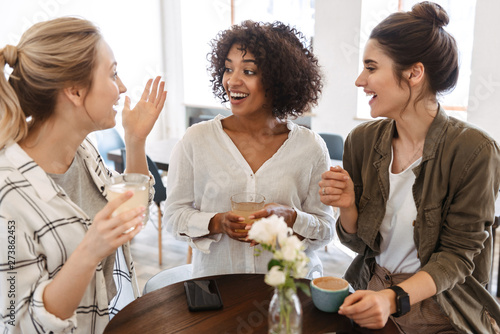 Happy young women friends having coffee break photo