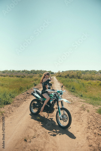 Fototapeta Naklejka Na Ścianę i Meble -  Young beautiful girl posing sitting on a motorcycle outdoors