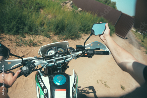 Young man sits behind the wheel of a motorcycle first-person view