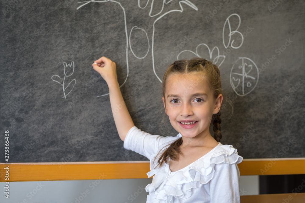Elementary student drawing on blackboard