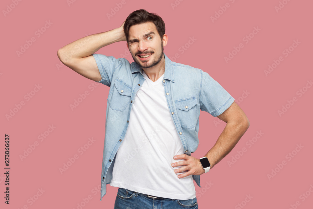 Portrait of query handsome bearded young man in blue casual style shirt standing and looking away and thinking what to do. indoor studio shot, isolated on pink background. Portrait of query handsome bearded young man in blue casual style shirt standing and looking away and thinking what to do. indoor studio shot, isolated on pink background.