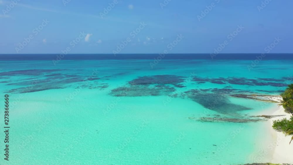 aerial drone pedestal down shot over fringing coral reefs near white sand beach of tropical island aerial drone pedestal down shot over fringing coral reefs near white sand beach of tropical island