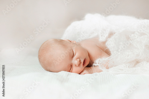 newborn babe lying on her stomach and learning to hold her head