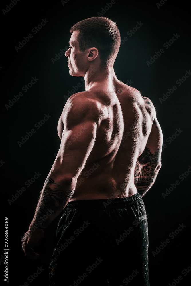 Fototapeta premium rear view.handsome male bodybuilder .isolated on black