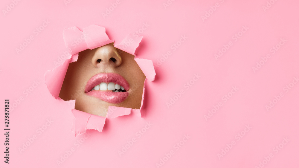 Woman Biting Lips Through Hole In Pink Paper