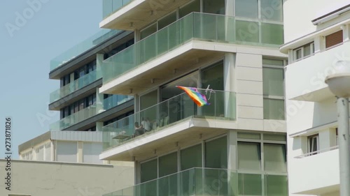 Gay Pride flag waving in the wind on an apartment building