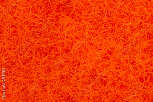 Bright orange surface of small intertwined hairs. Nanofibers and super macro zoom. Abstract orange background and pattern. Tangled lines. Magnified surface under the microscope.